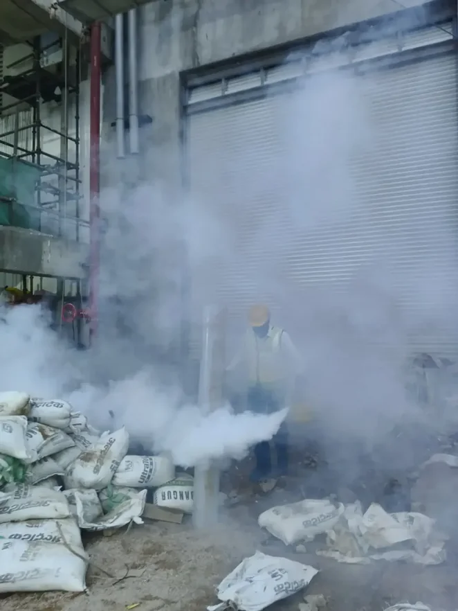 Pest control technician carrying out fogging treatment in a commercial storage area